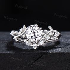 a white gold engagement ring with an oval center stone surrounded by leaves and round brilliant cut diamonds