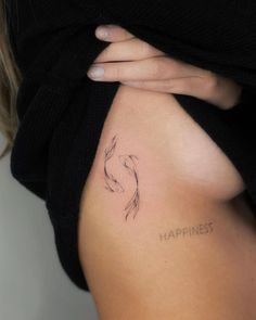 a woman's stomach with the word happiness written on it and a goldfish tattoo