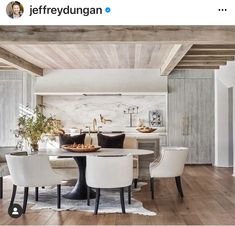 the dining room table is surrounded by white chairs and an area rug that looks like wood