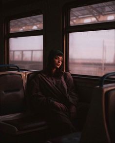 a woman sitting on a train looking out the window