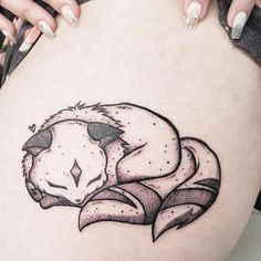 a woman's thigh with a black and white drawing of a bear on it