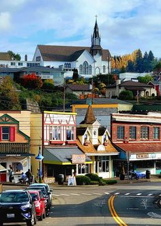 the town has many colorful buildings and cars parked on the street in front of it