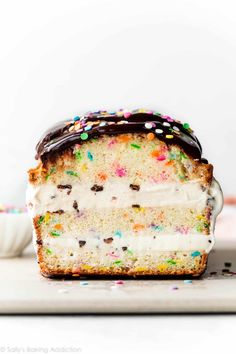 a slice of cake with white frosting and sprinkles