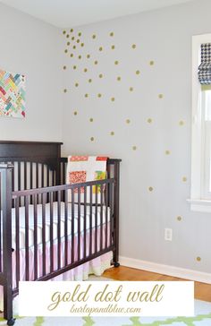 a baby's room with polka dot wall decals and a crib in the corner