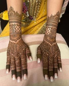 a woman's hands with hennap on her arm and feet, decorated with intricate