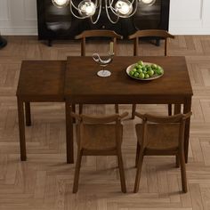 a dining room table with chairs and a bowl of fruit on the table in front of it