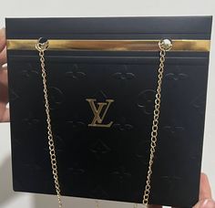 the louis vuitton necklace is being held up in front of a black box