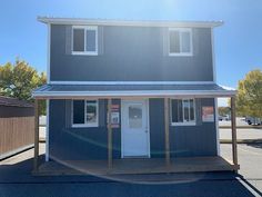 a two story house sitting on top of a parking lot