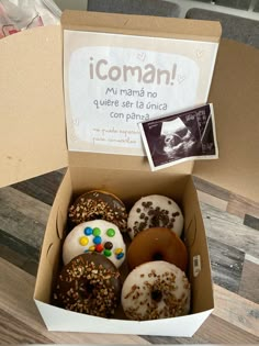 a box filled with lots of donuts covered in sprinkles and toppings