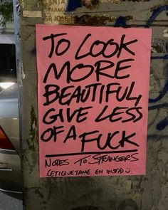 a pink sign that says to look more beautiful give less affick written on it