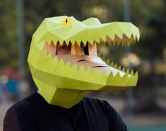 a person wearing a paper mask with a large alligator's head on their face