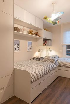 a bed room with a neatly made bed next to a window and a wooden floor