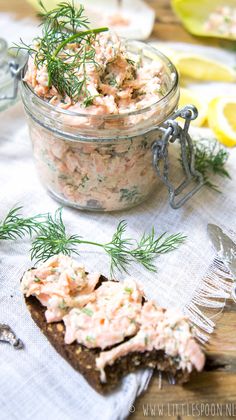 a glass jar filled with food sitting on top of a table next to a slice of bread