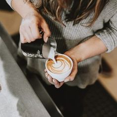 a woman pours coffee into a cup