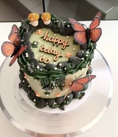 a birthday cake decorated with butterflies and the words happy baby on it's side