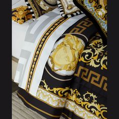 a bed with black and gold comforters on top of it