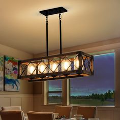 a chandelier hanging from the ceiling in a dining room with chairs around it