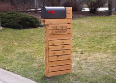 a wooden mailbox sitting in the grass