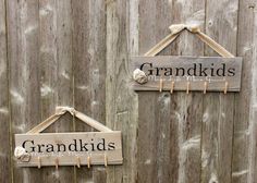 two wooden signs hanging on the side of a fence that says grandkids and grandkids