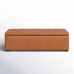 a brown leather bench with buttons on the top and bottom, in front of a white background