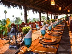 a long table with plates and place settings set for an outdoor dining area at the resort