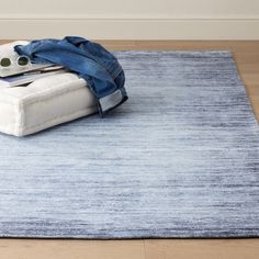 a blue and white area rug on the floor with clothes laying on top of it