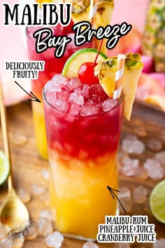 two glasses filled with drinks sitting on top of a wooden table next to sliced pineapples