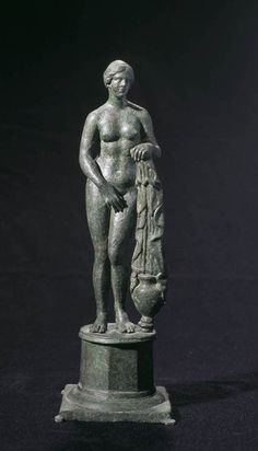 a statue is standing on a pedestal with an object in it's hand,