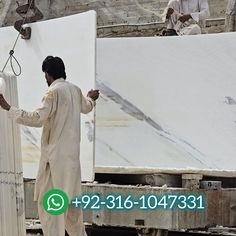 a man standing next to a pile of white marble