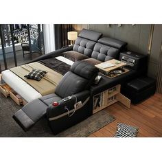 a black leather reclining bed with pillows on it