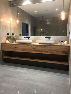 a bathroom with two sinks and a large mirror over it's counter top area