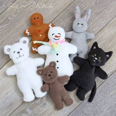 there are many different stuffed animals on the wooden floor, one is black and one is white