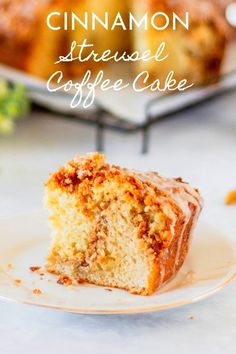 a slice of coffee cake on a plate with the rest of the cake in the background