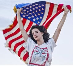 a woman holding an american flag in her hands