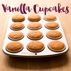 a pan filled with vanilla cupcakes on top of a wooden table