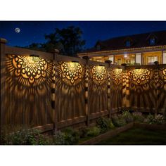 a wooden fence with decorative laser cutouts on the top and side panels at night