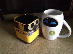 two coffee mugs sitting next to each other on the floor in front of a microwave