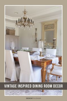 a dining room table with white chairs and a chandelier