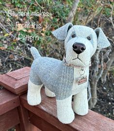 a knitted dog is sitting on a wooden bench with the words student makes from this pattern