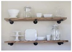 two wooden shelves with white dishes and vases on them