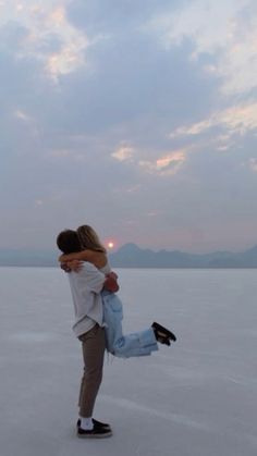 a man and woman are hugging on the beach