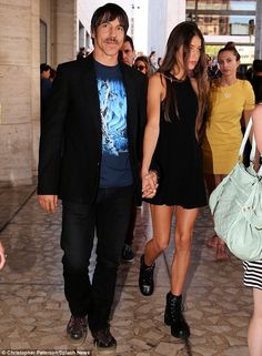 a man and woman holding hands as they walk through an airport