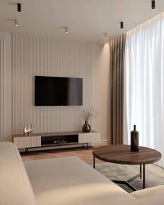 a living room with a large flat screen tv mounted on the wall above a wooden coffee table