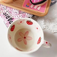 two coffee mugs sitting next to each other on top of a doily covered table