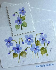 two stamps with blue flowers painted on them