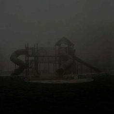 a playground in the fog with a slide