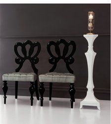 two black and white chairs sitting next to each other in front of a candle holder