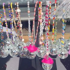 several disco balls and necklaces hanging from a rack