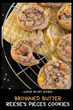 chocolate chip cookies are cooling on a wire rack with candy corn and candies in the middle