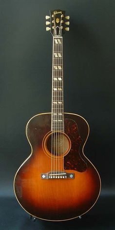 an acoustic guitar is shown against a black background